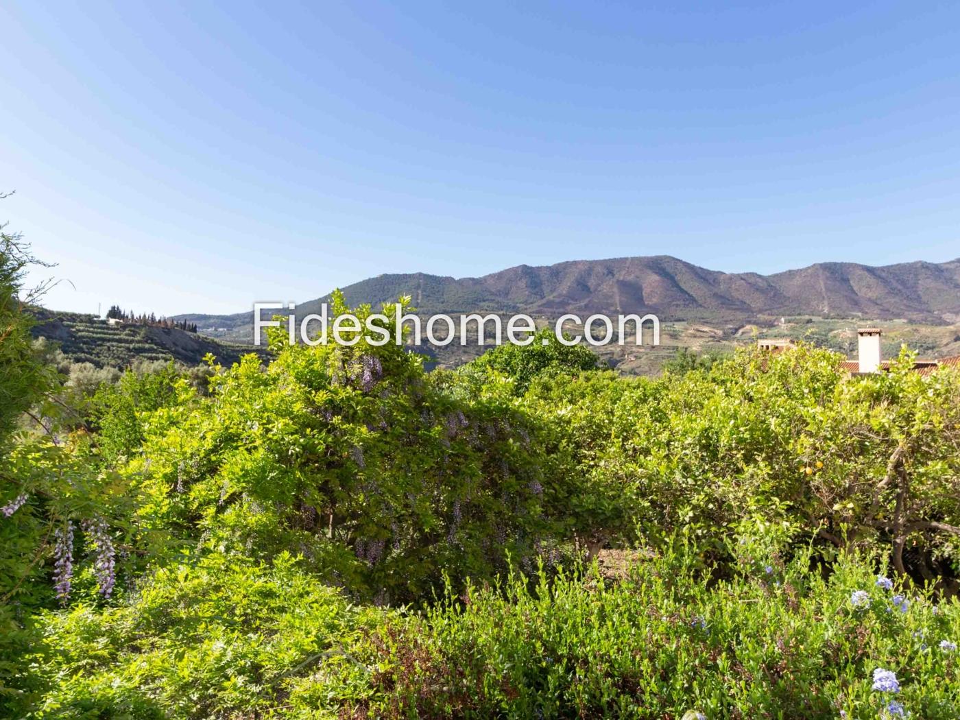 Edificio de dos plantas con gran jardín en Melegís en Melegís