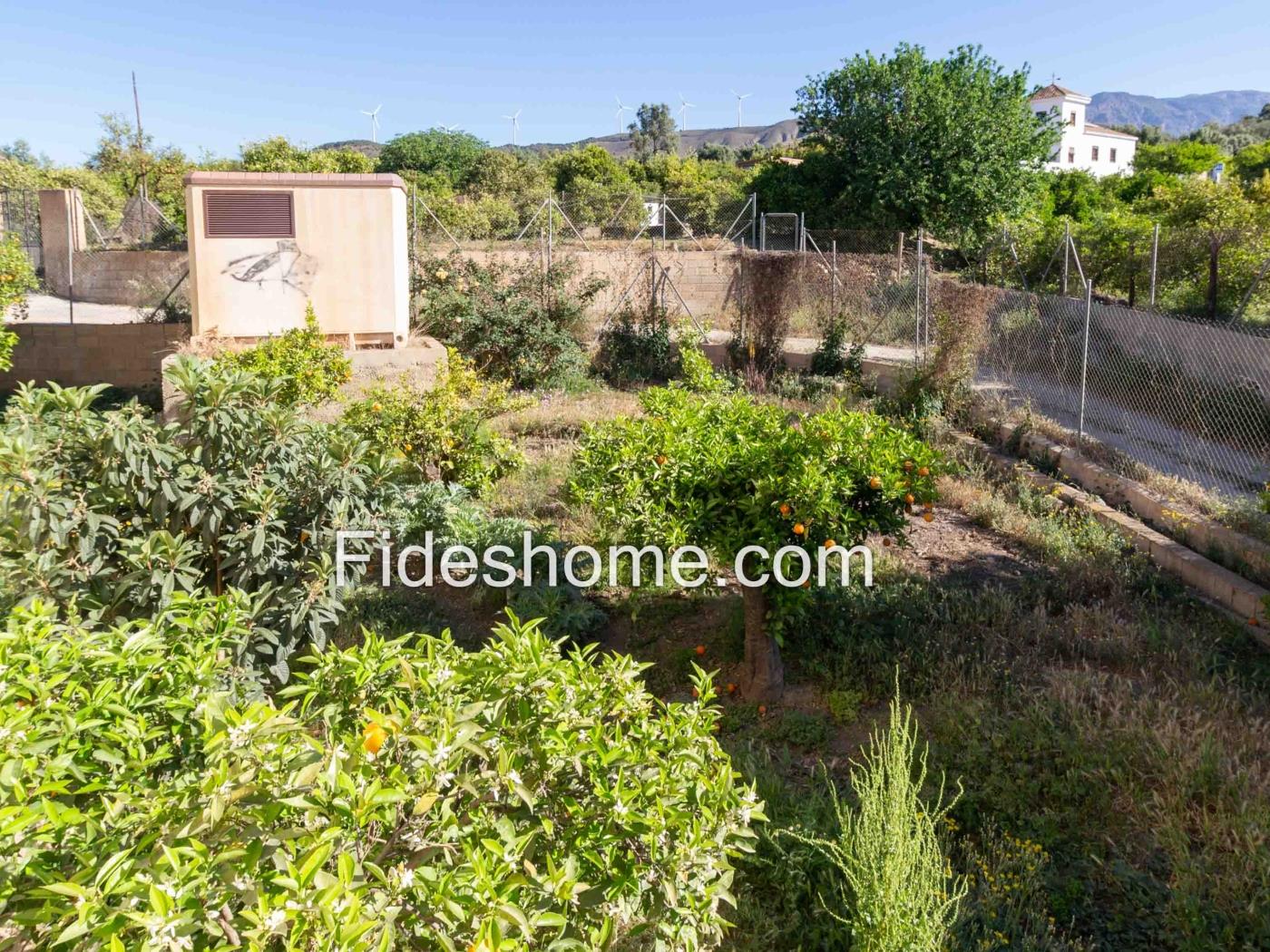Edificio de dos plantas con gran jardín en Melegís en Melegís