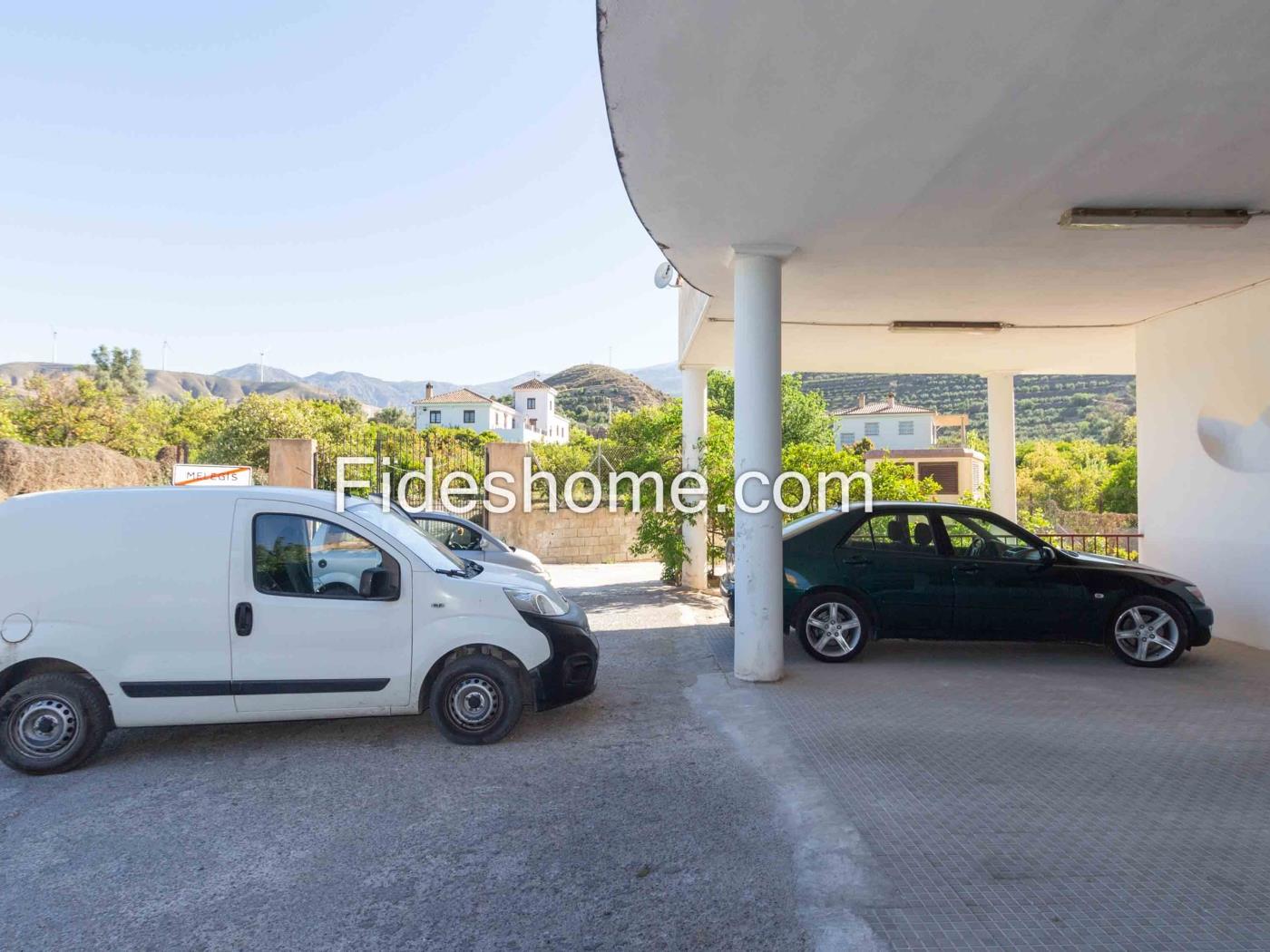 Edificio de dos plantas con gran jardín en Melegís en Melegís